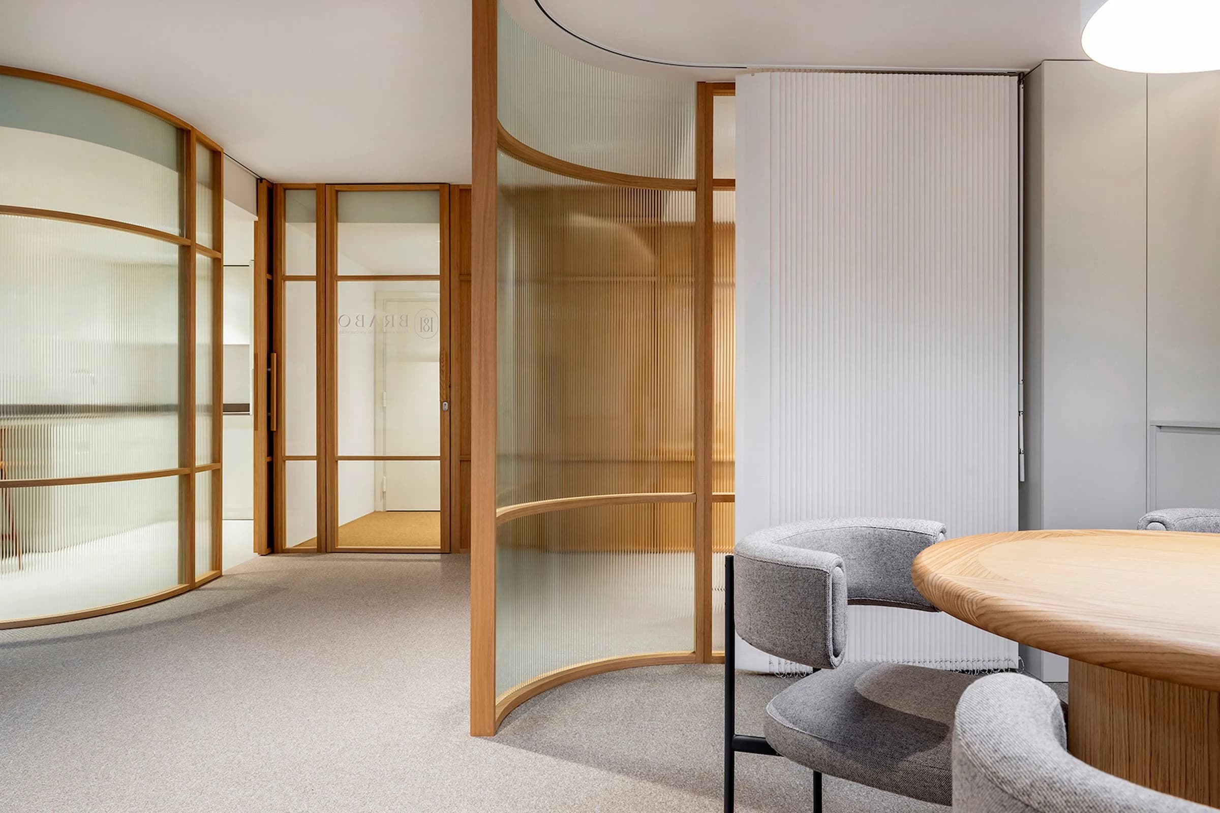 Premium office fit-out with curved timber-framed glass partitions, wall panels and carpet flooring