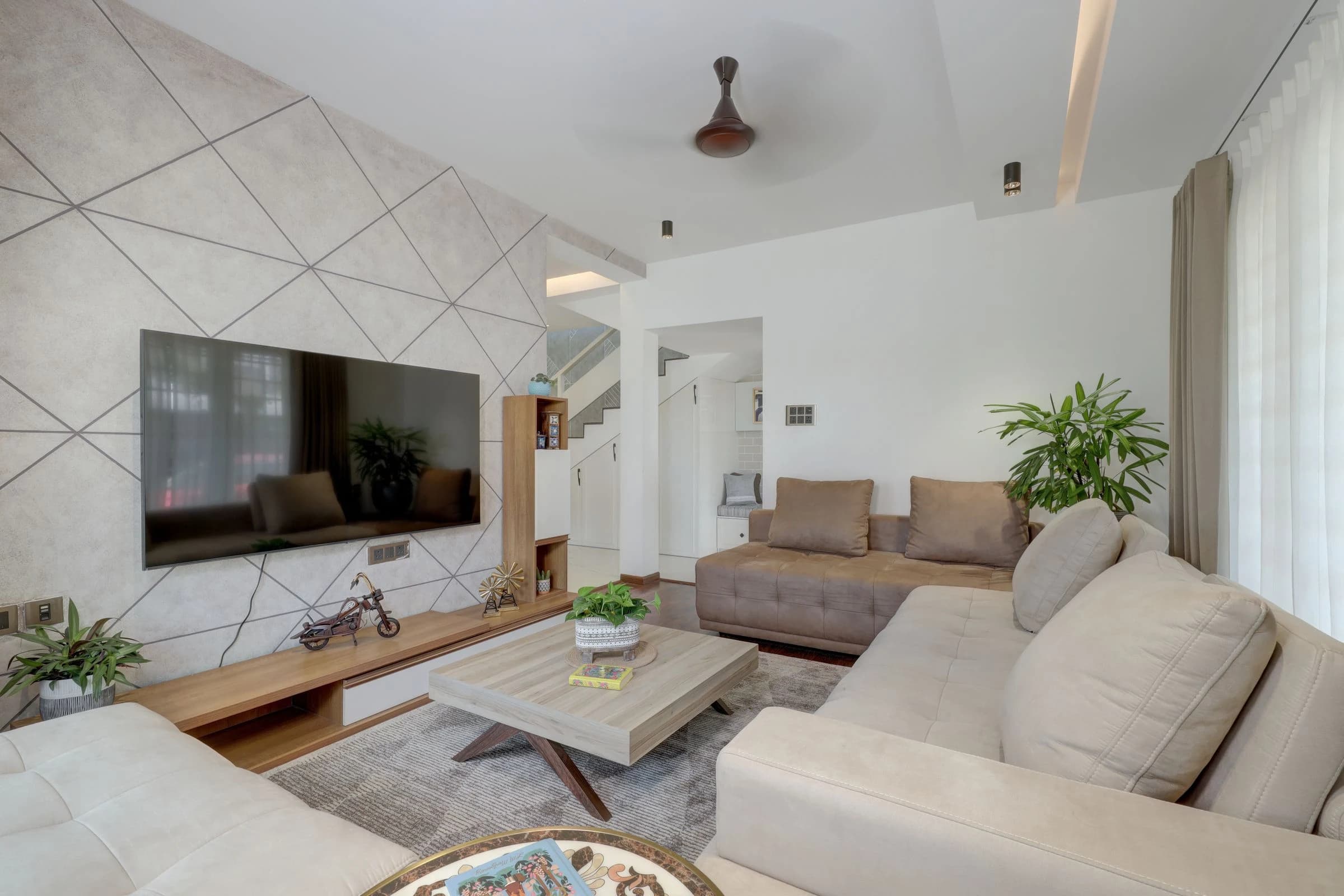 جدار زخرفي بتصميم هندسي خلف التلفاز في غرفة معيشة معاصرة