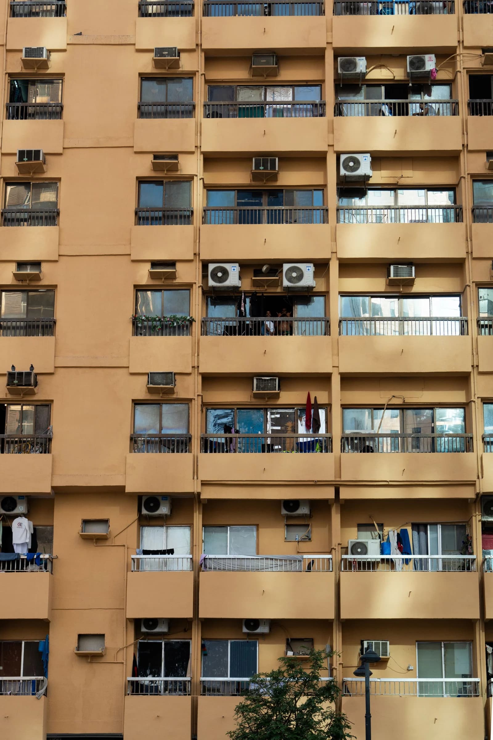 Outdoor air-conditioning condenser units beside apartment balconies in Abu Dhabi