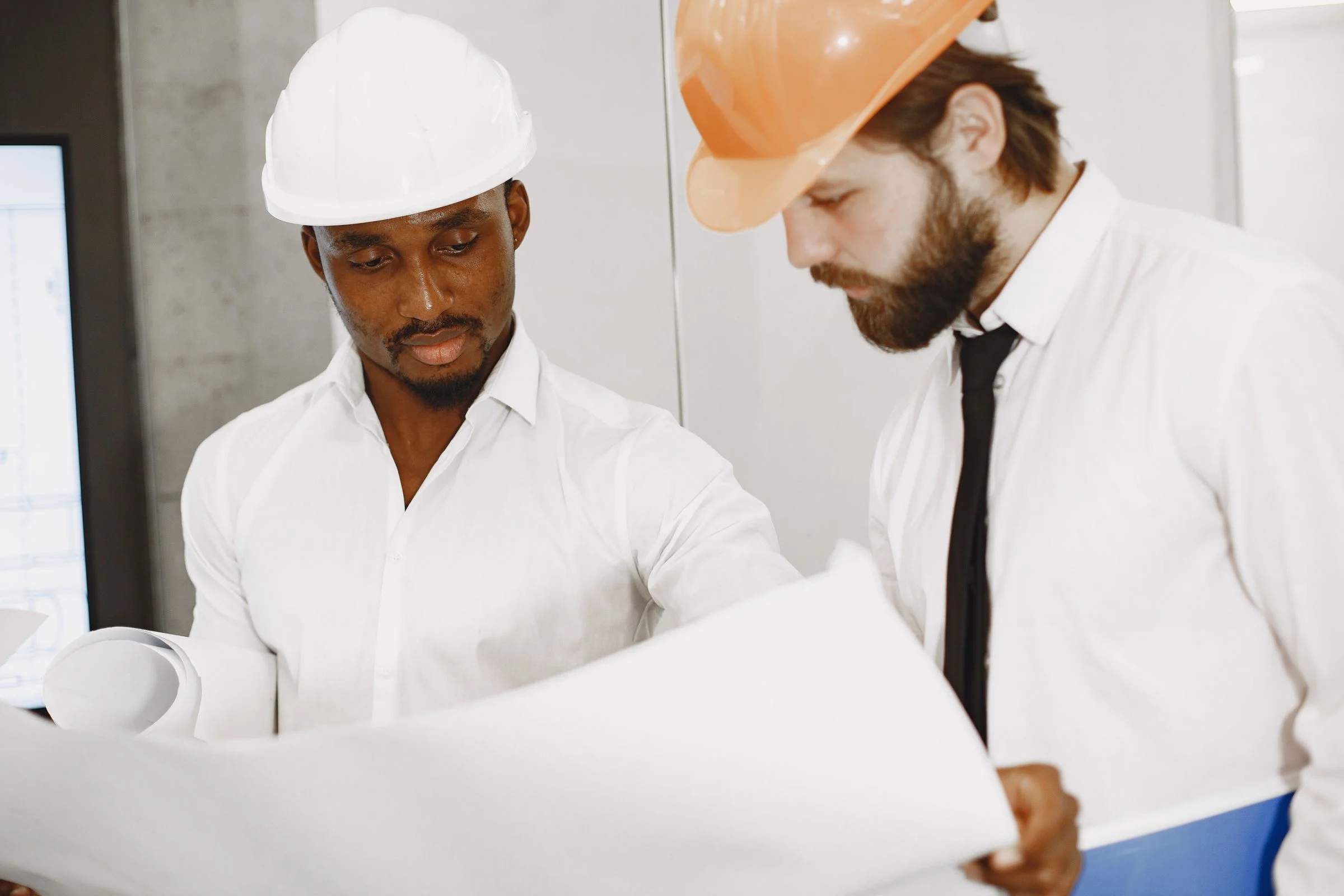Two engineers reviewing building plans together